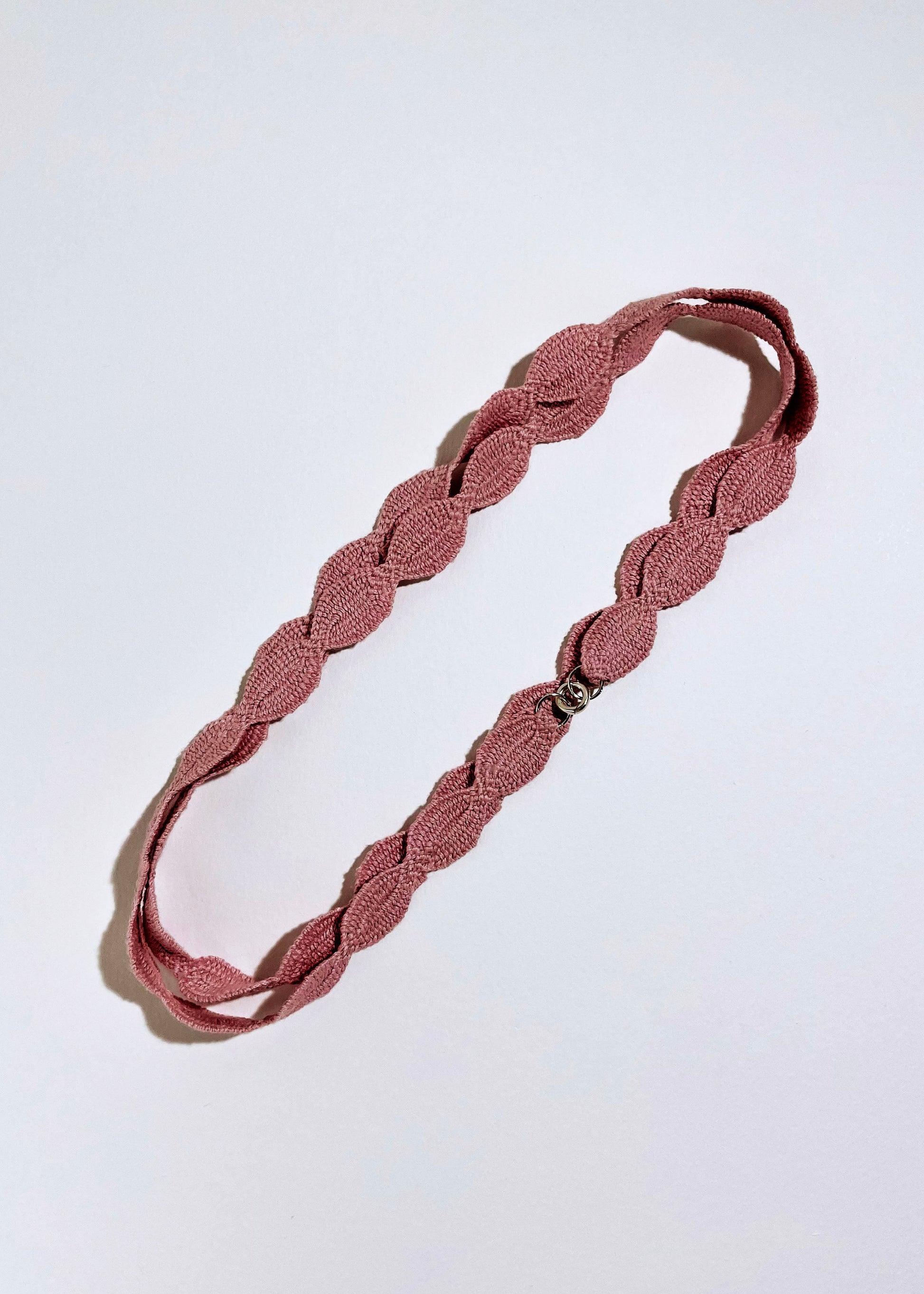 Overhead pink cotton woven ovals necklace with Sterling Silver endings placed in a double loop on a white background
