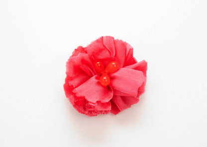 Front view of a rose red silk flower charm and  connector with glass bead trio detail centre on a white background.