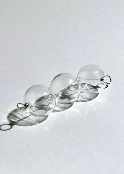 Diagonal front view of a chunky clear glass beaded chainlet under headlight with Sterling Silver looped endings in a white background