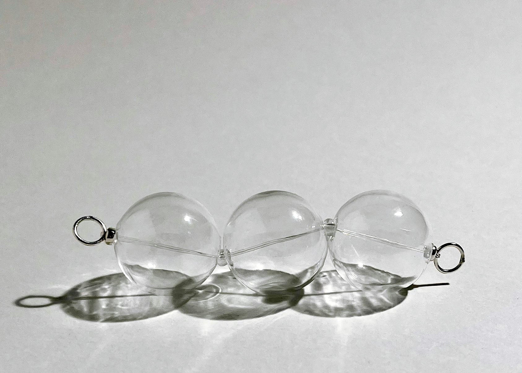 Front view of a chunky clear glass beaded chainlet with Sterling Silver lopped endings on hard light on a white background