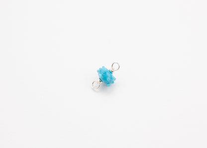 Front view of lampwork blue glass urchin charm with Sterling Silver endings on a white background