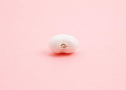 Close up of the Sterling Silver looped endings detail of white lampwork glass heart charm on a pink background