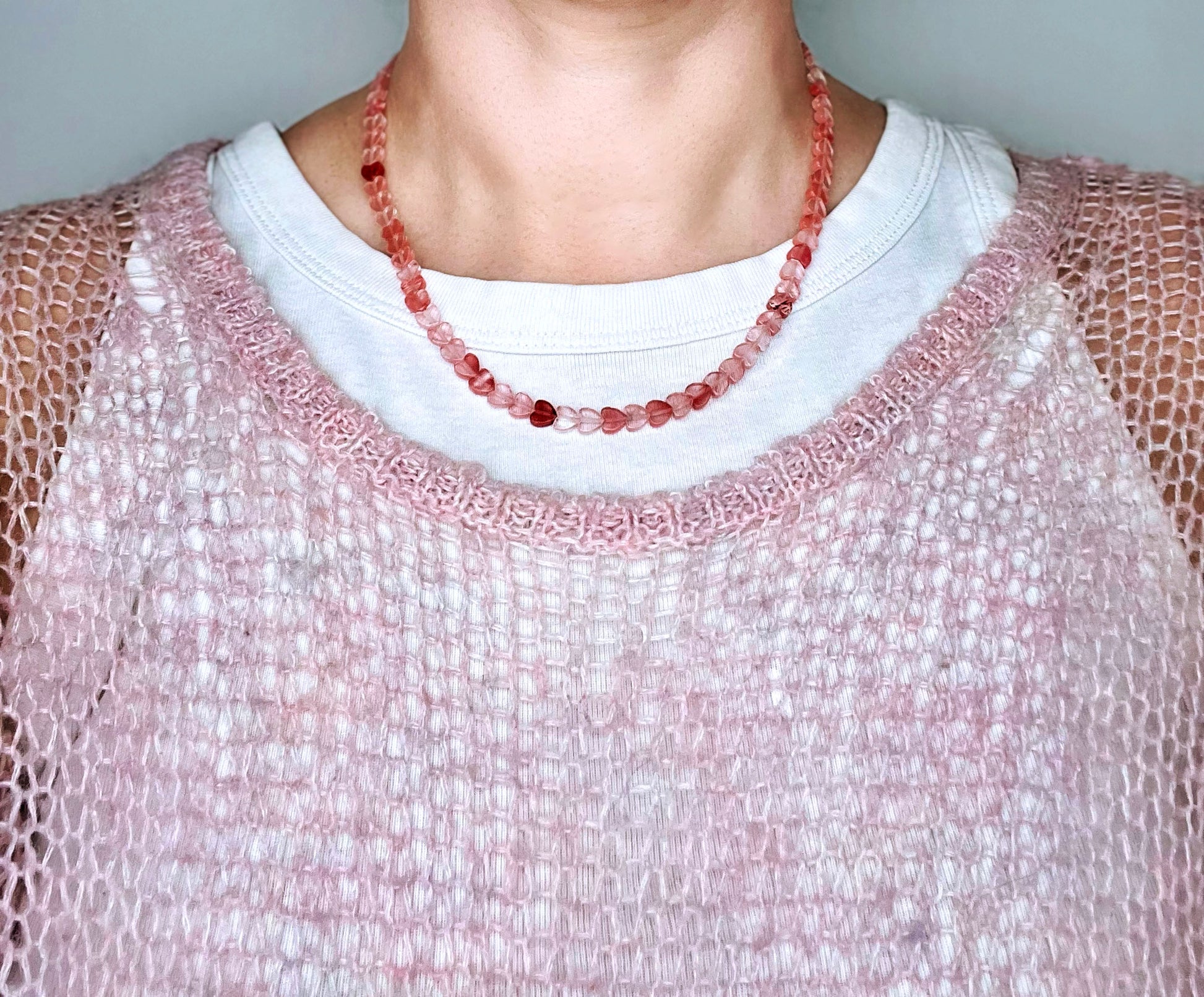 Front view of a woman wearing a cherry quartz pink heart beads necklace 