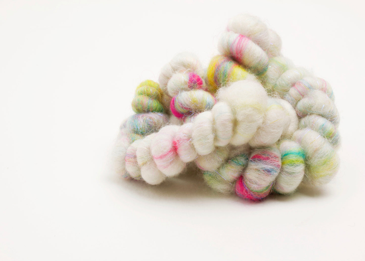 Front fabric detail of a wool yarn necklace in a knot in ivory, with bright colours accents with Sterling Silver looped endings on a white background